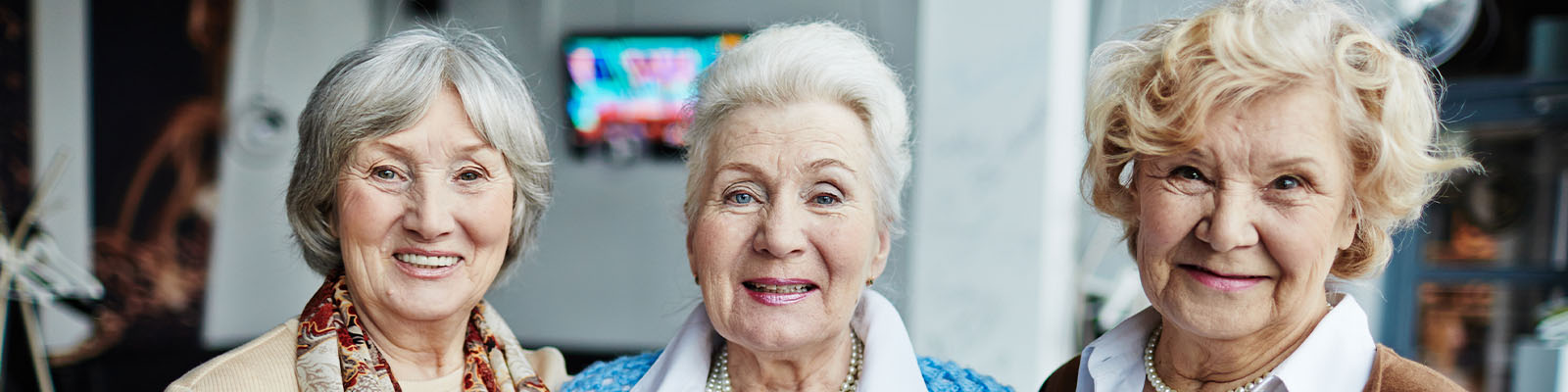 Three senior women standing together and smiling